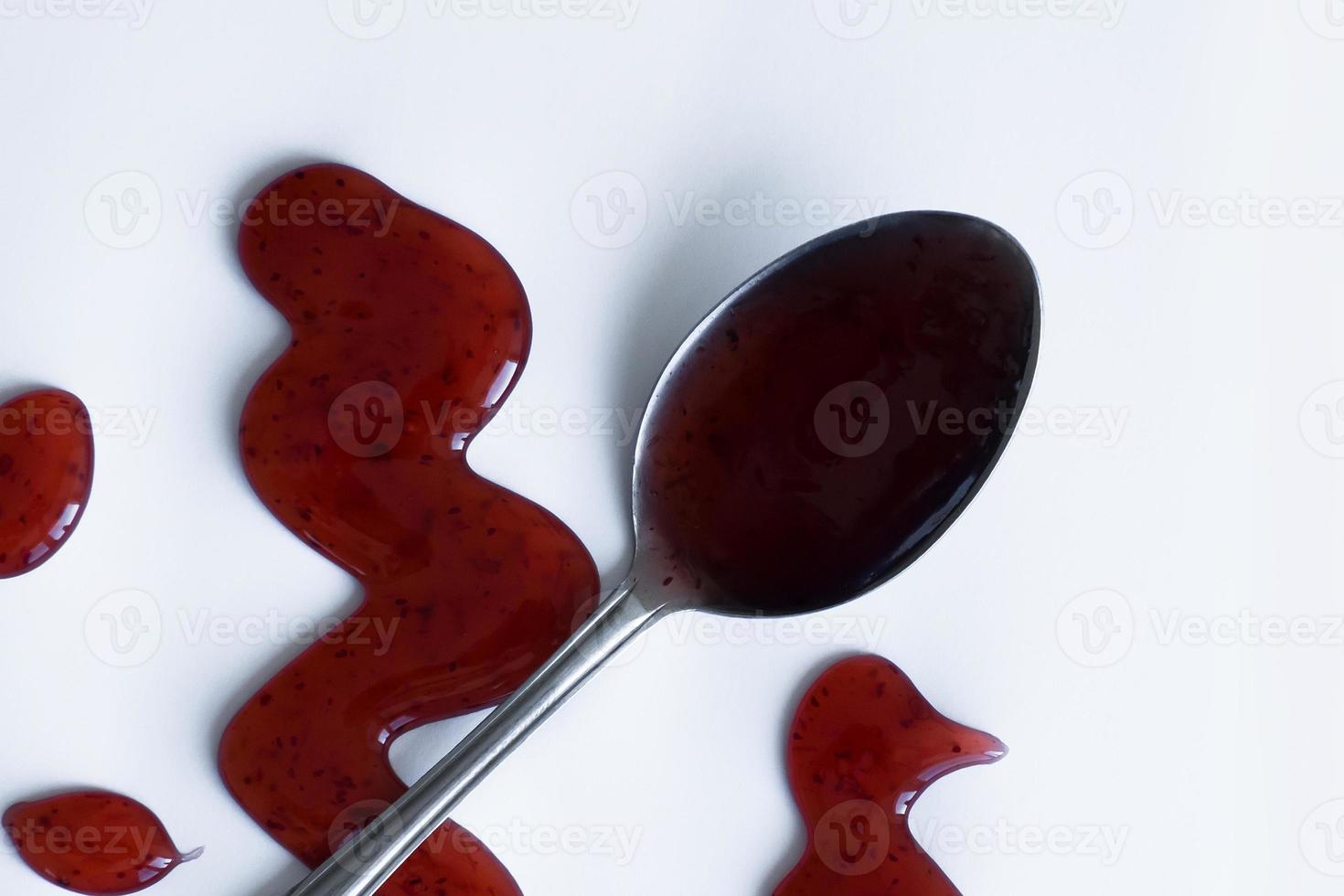 the drops of homemade sauce and a spoon on a white background photo