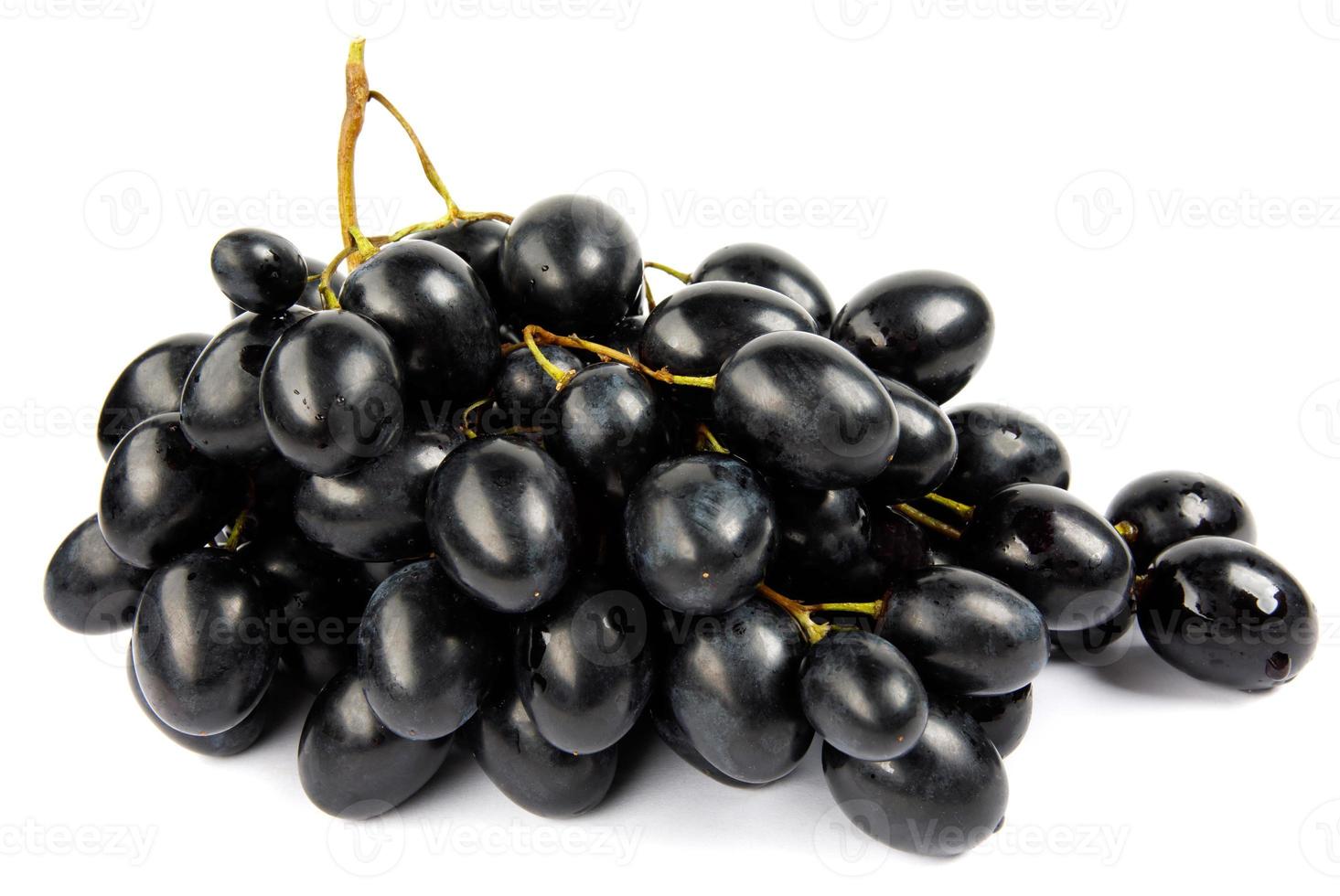 un racimo de uvas negras está aislado en un fondo blanco. foto