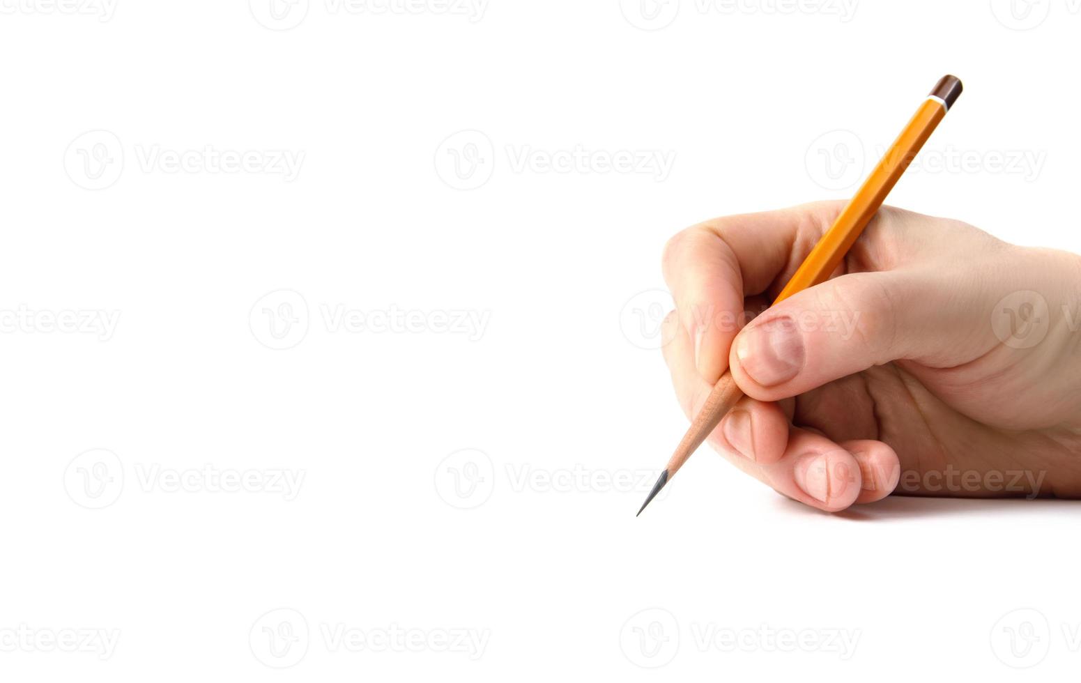The hand holds an acutely sharpened pencil. photo