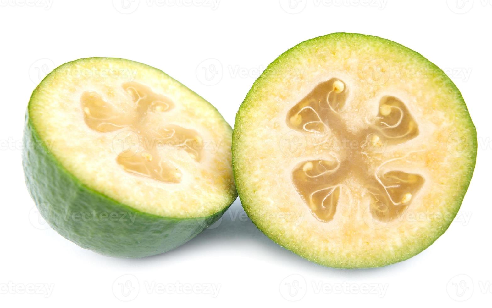 dos mitades de la fruta feijoa madura están aisladas en un fondo blanco. foto