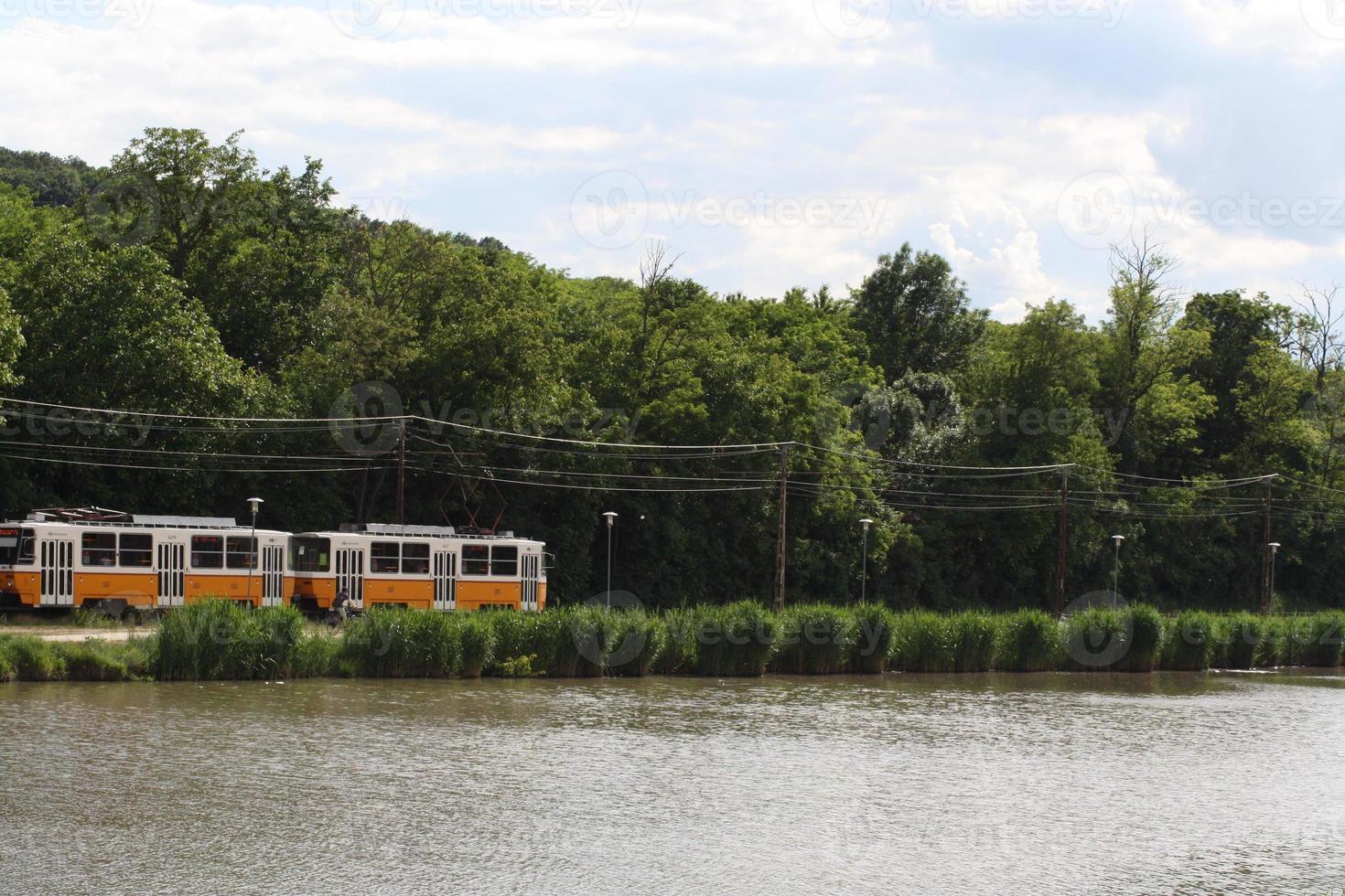 View of the tram and budafok lake with green trees photo