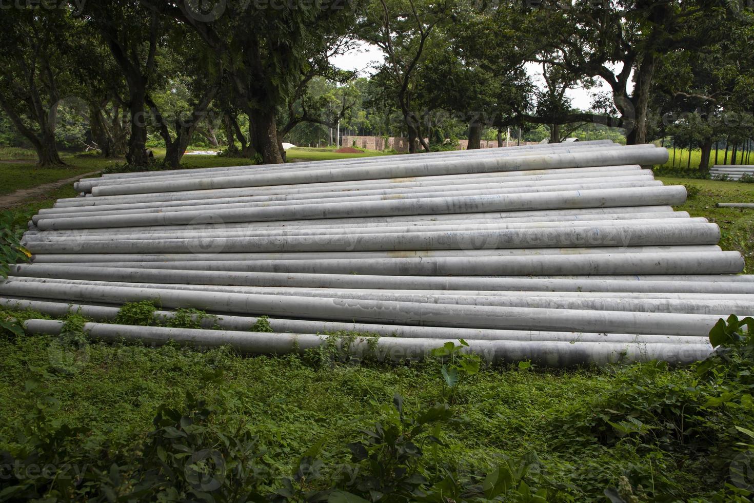 Concrete cylindrical electric pole  in the greenery Field photo