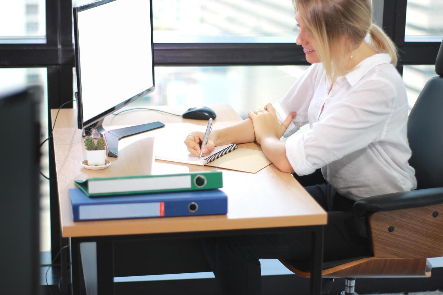 Portrait of a businesswoman working with laptop in a bright office photo