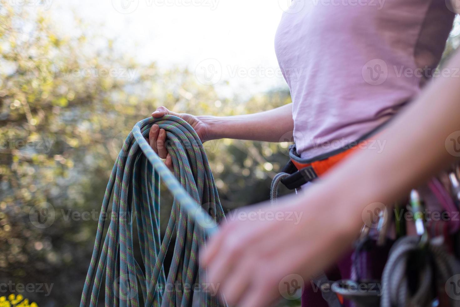 A rock climber coils a rope photo
