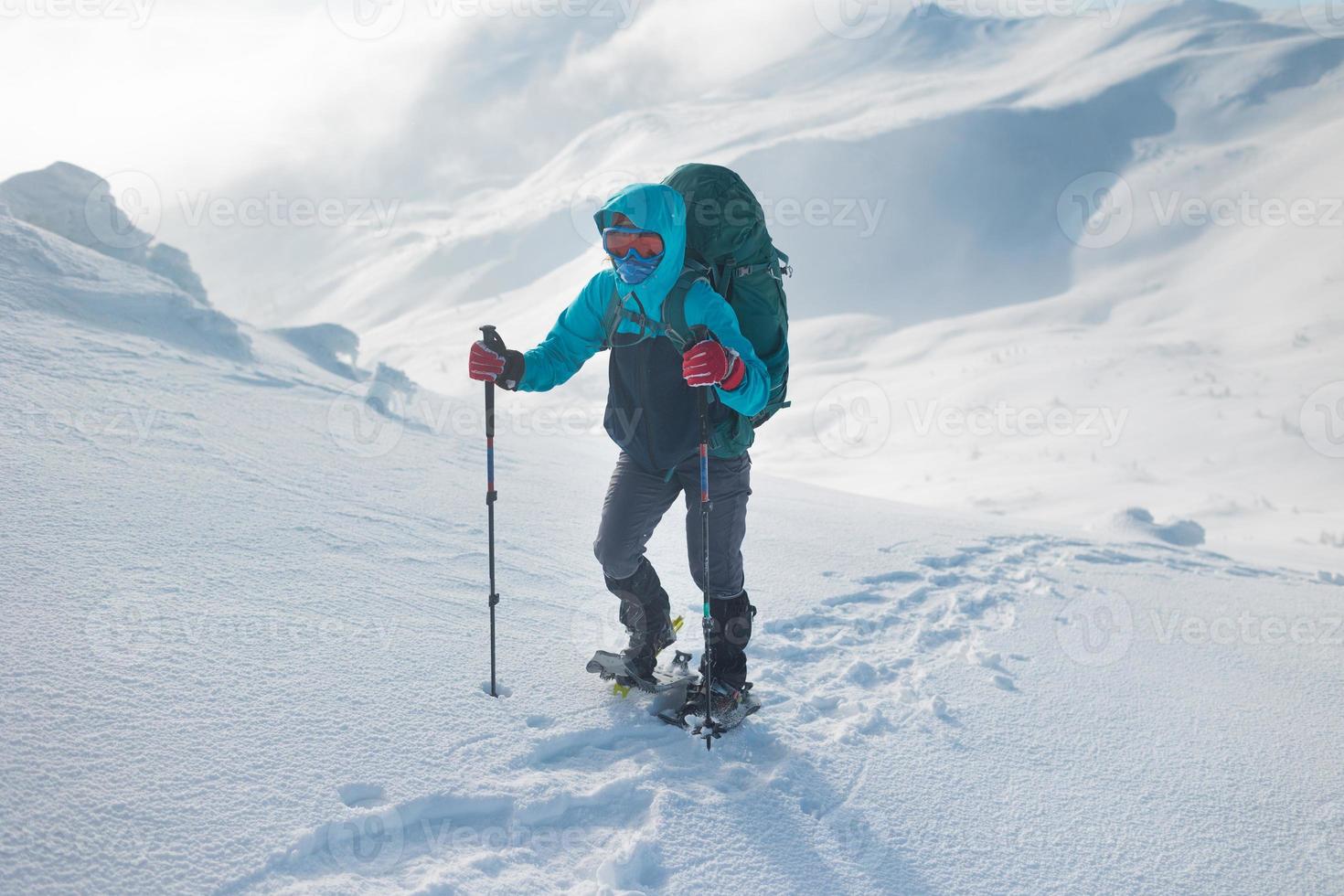 A hiker walks in snowshoes in the snow photo