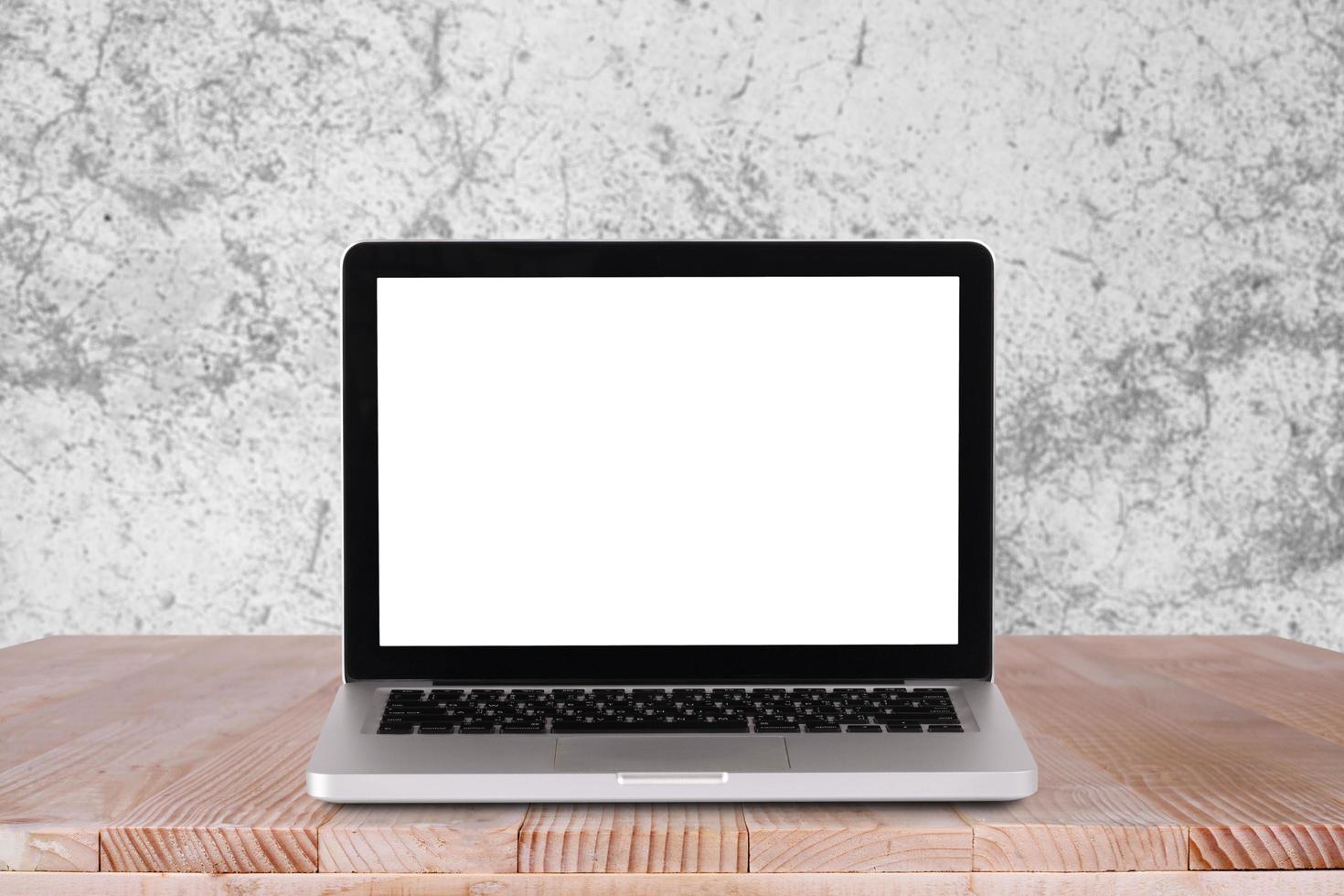 Front view of the laptop is on the work table with white concrete background photo