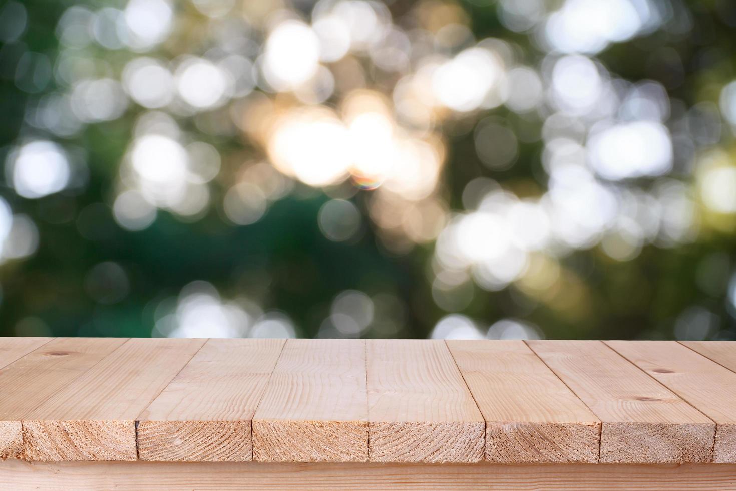 mesa de madera sobre fondo verde abstracto bokeh - se puede utilizar para montar o mostrar sus productos foto