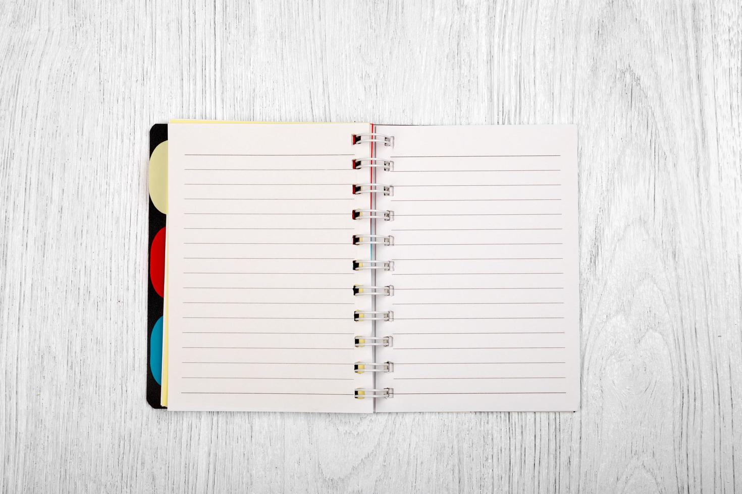 Open notebook and a pencil on white wooden table, top view photo