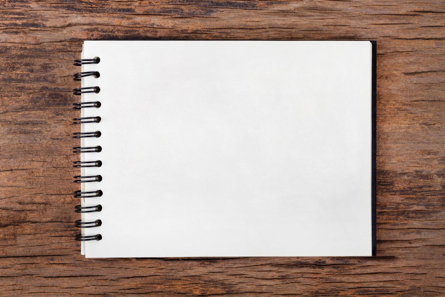 Blank empty notepad on wood background photo