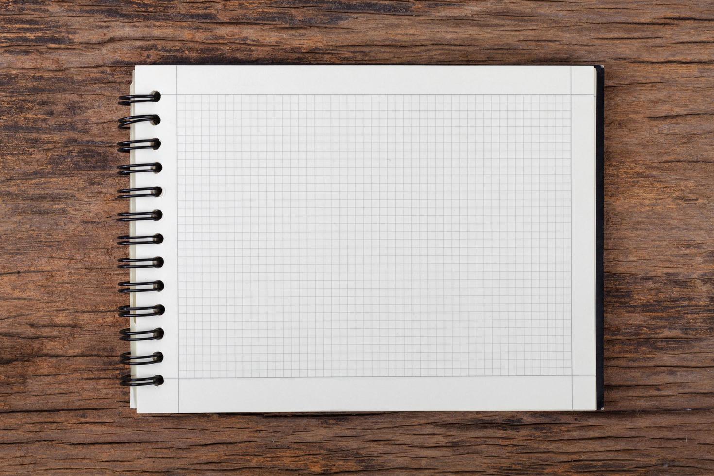 Blank empty notepad on wood background photo