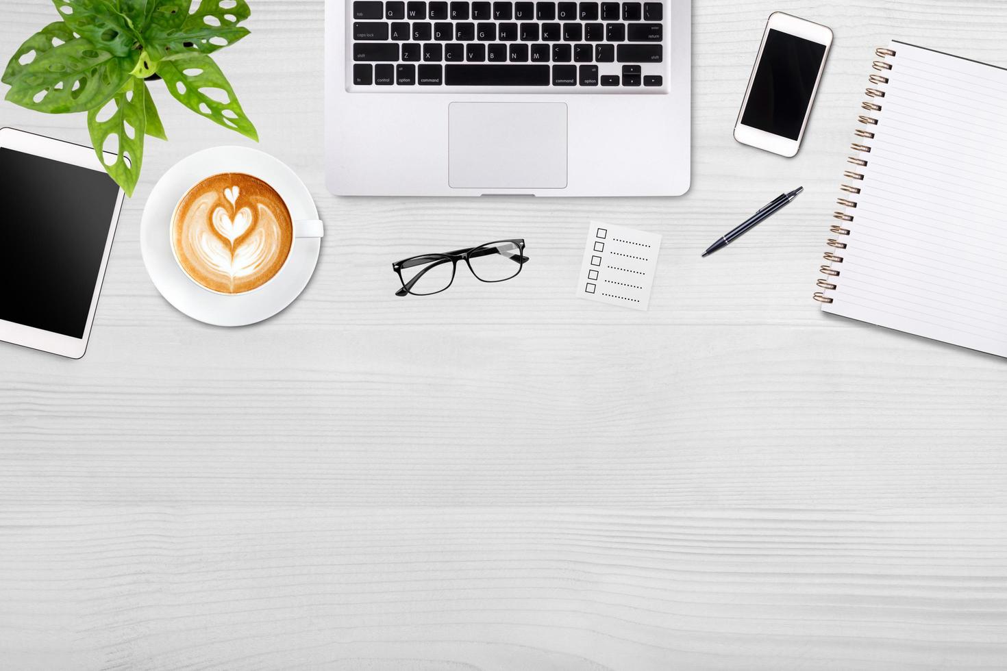 Modern workspace with laptop tablet, smartphone and coffee cup copy space on white wood table background. Top view. Flat lay style. photo