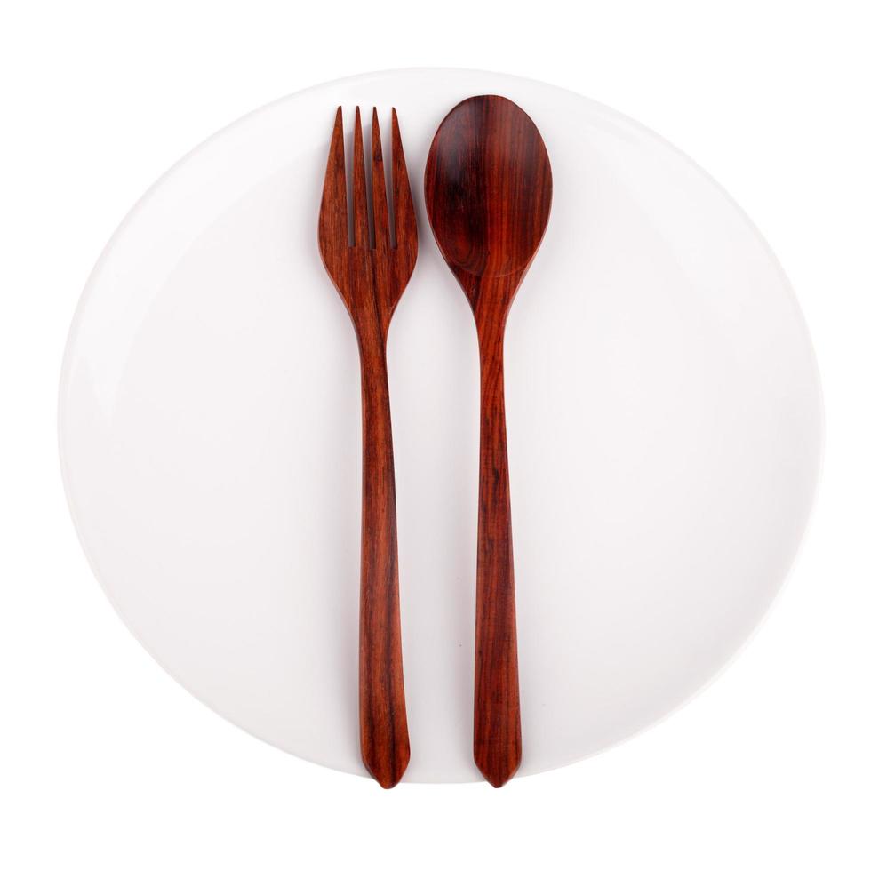 Wood spoon, fork and plate isolated on white background photo