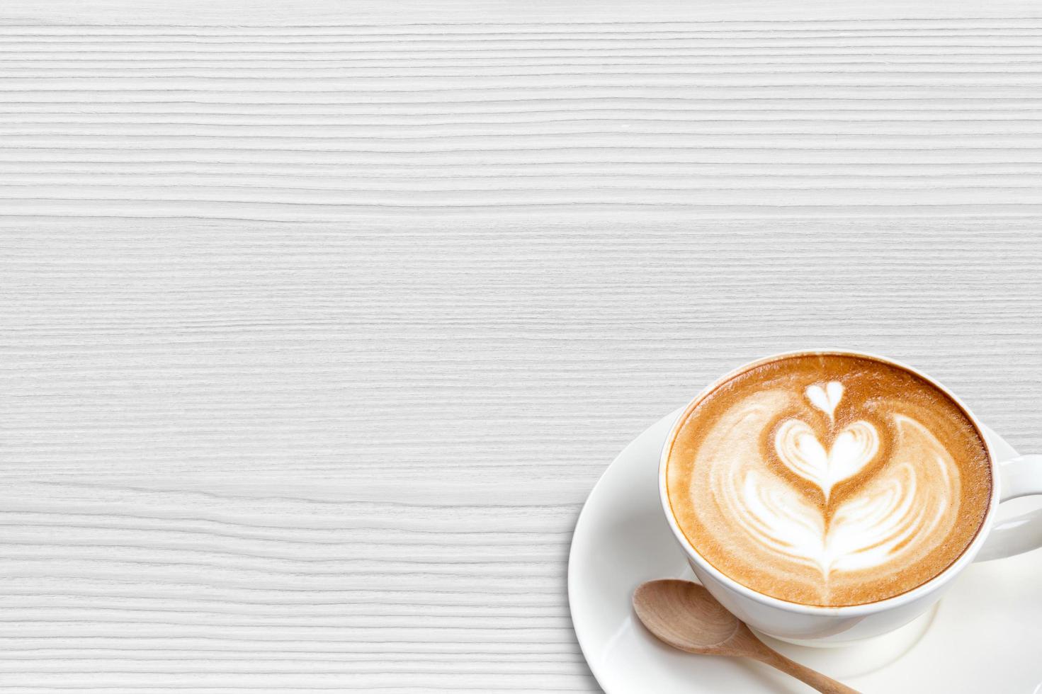 A cup of coffee latte with spoon on wood blackground photo