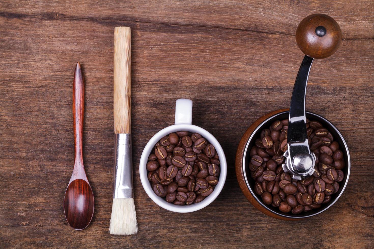 cup of coffee beans and spoon on the brown wooden background photo