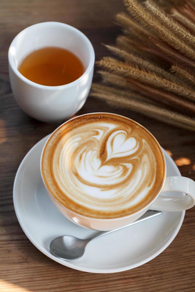 café latte art con té sobre fondo de madera foto