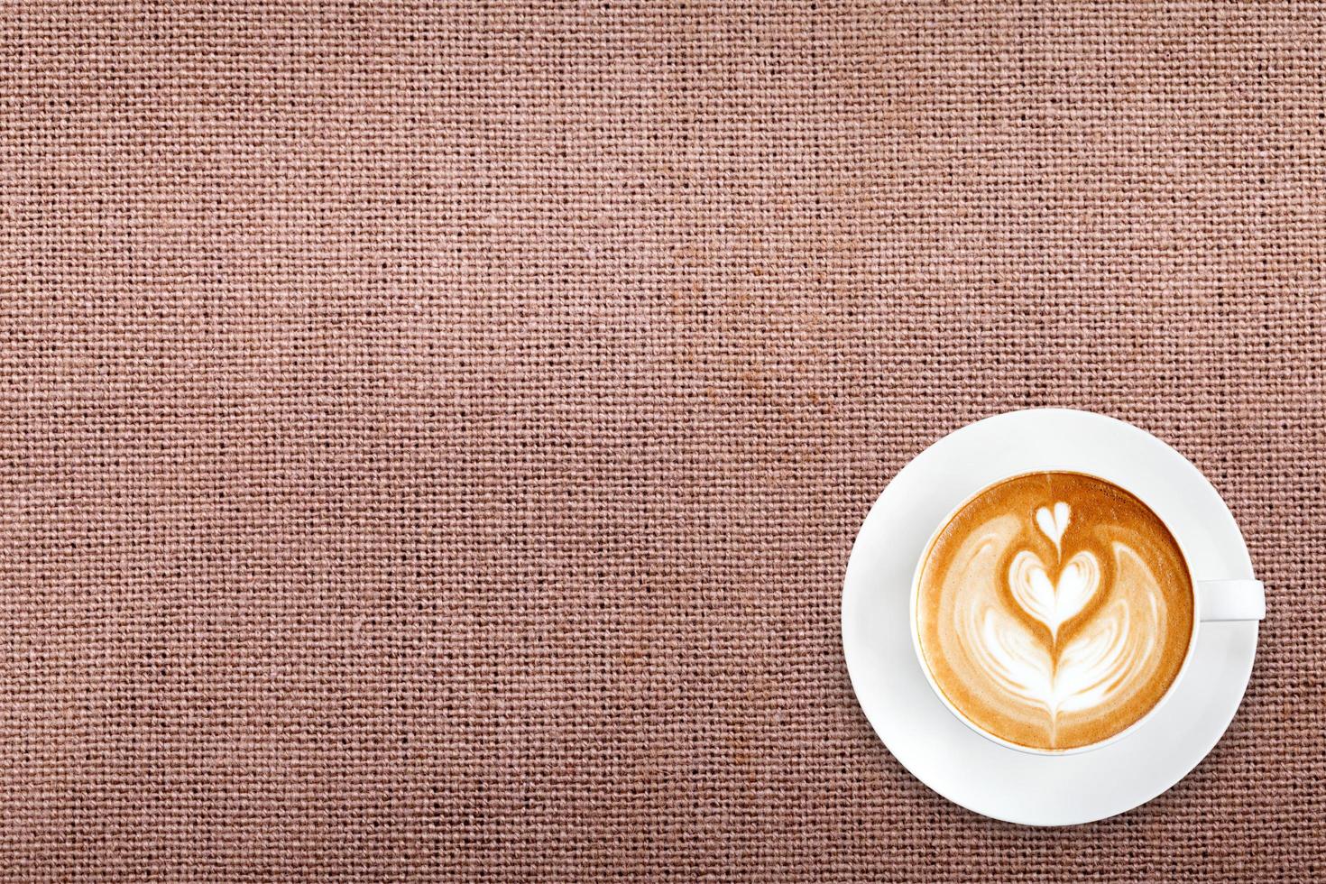 Top view latte art coffee on cotton fabric background photo