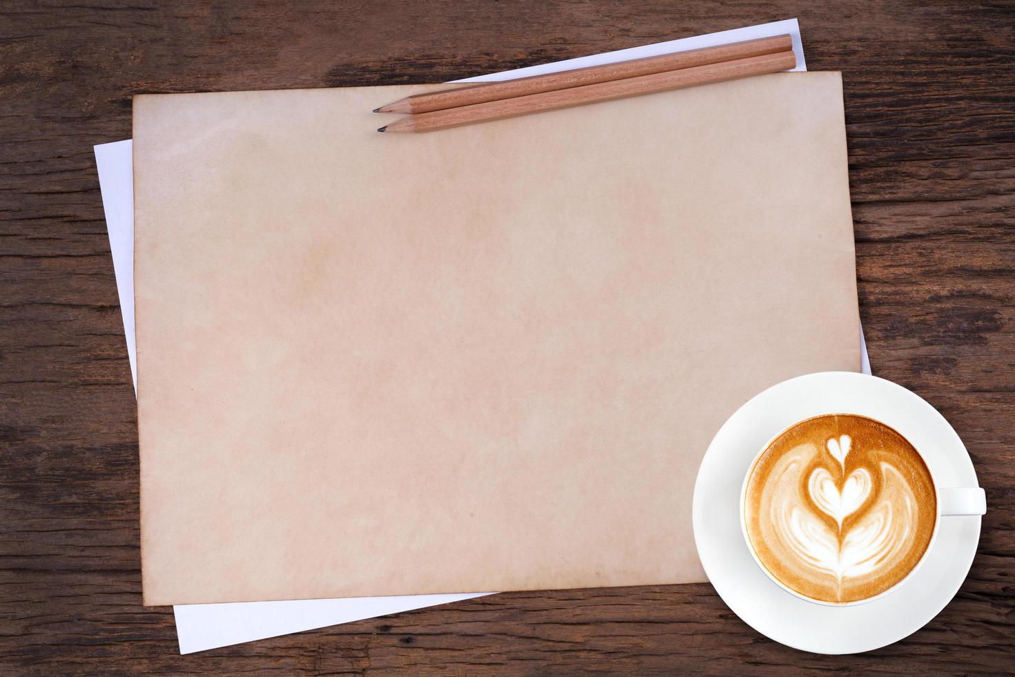 blank paper with pencil and a cup of coffee on wooden photo