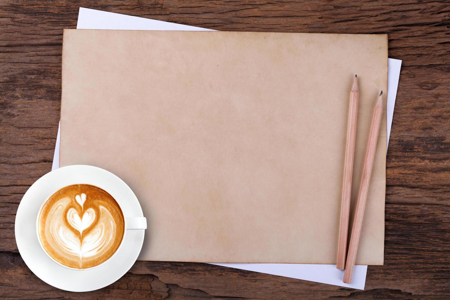 blank paper with pencil and a cup of coffee on wooden photo