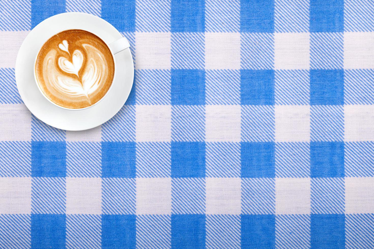 Top view latte art coffee on fabric textile texture background photo