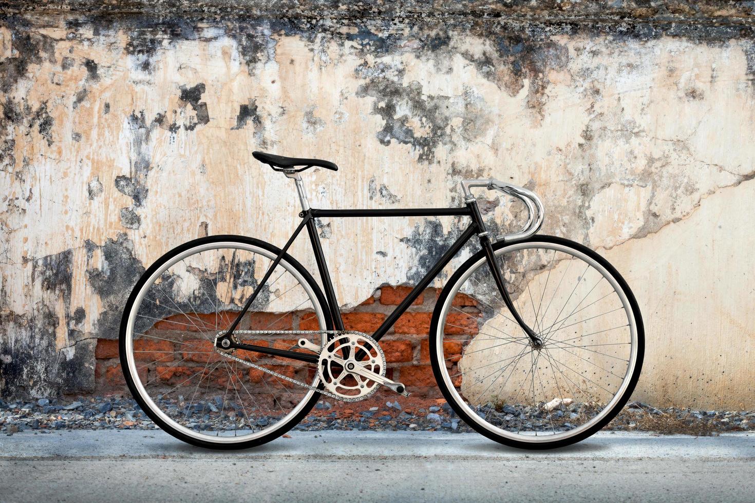 equipo fijo de la bicicleta de la ciudad y fondo viejo de la pared del hormigón agrietado foto