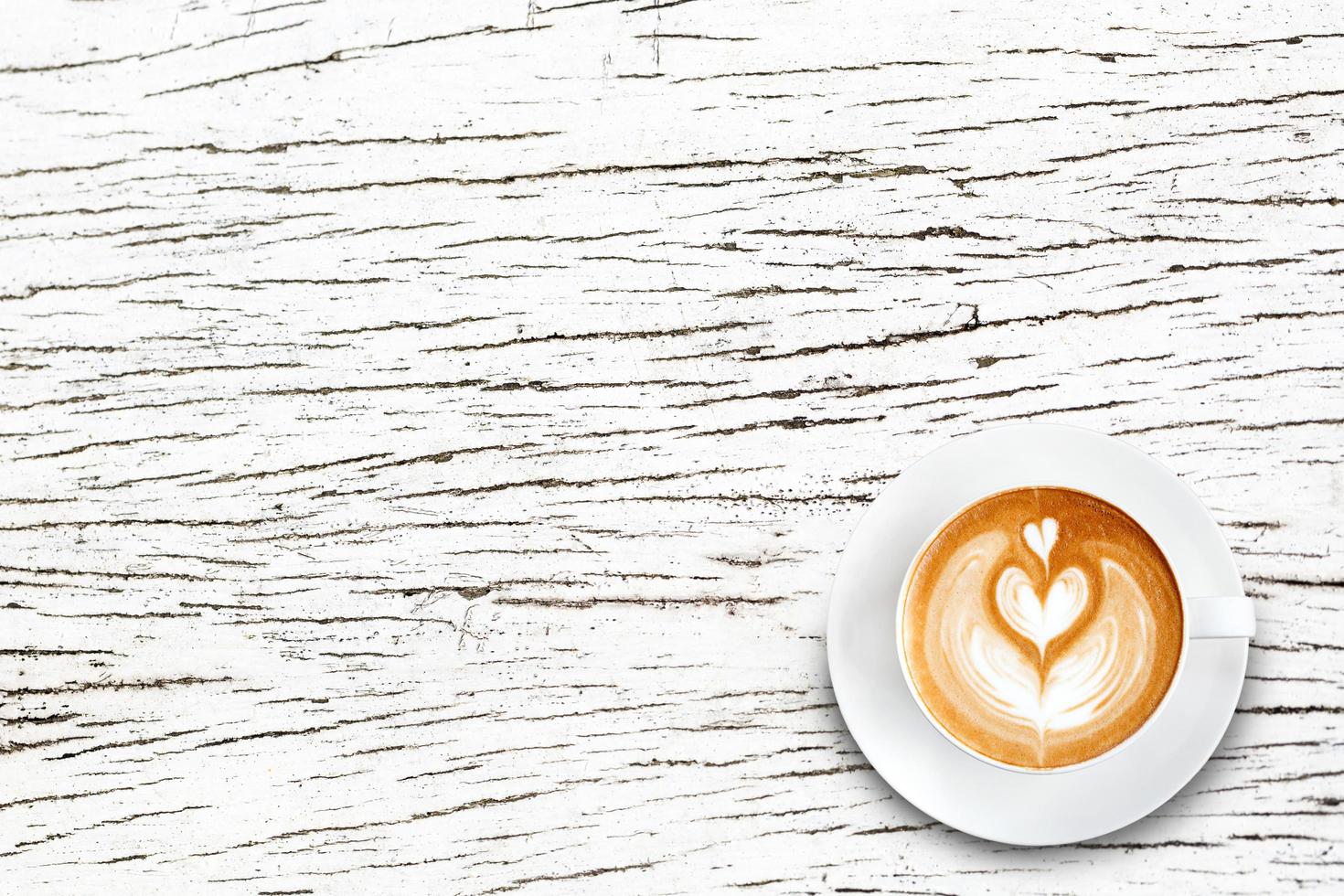 Top view latte art coffee on white wood photo