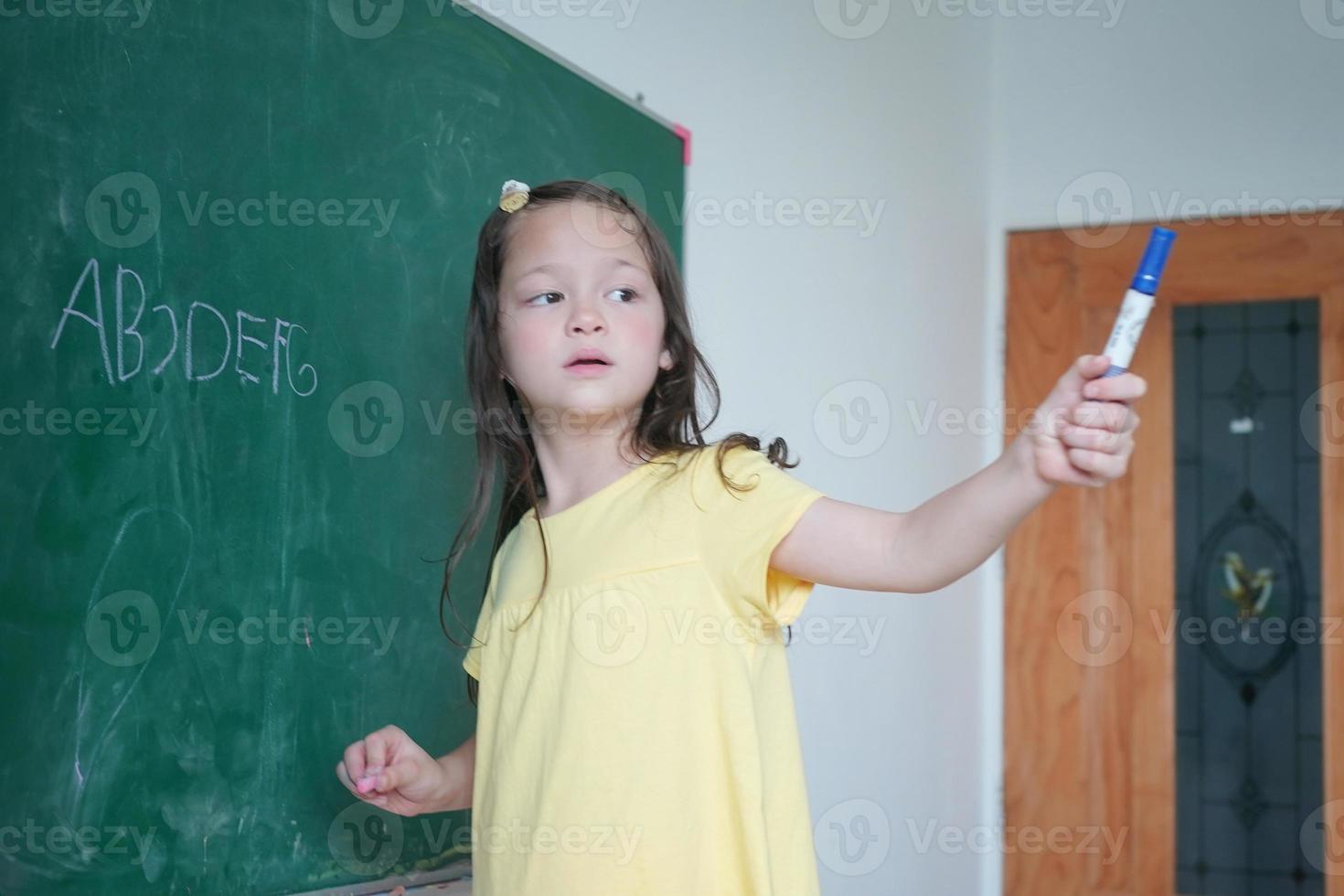 Happy little Girls against Chalkboard With Back To School photo