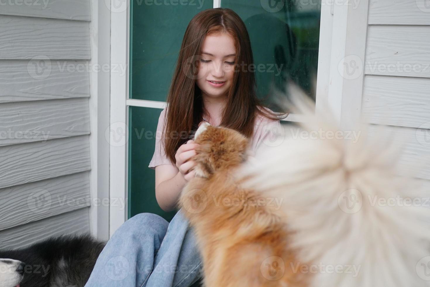 young girl in casual clothes hugging golden retriever while sitting on floor photo