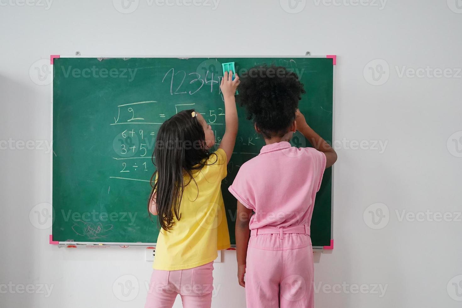 Happy little Girls against Chalkboard With Back To School photo
