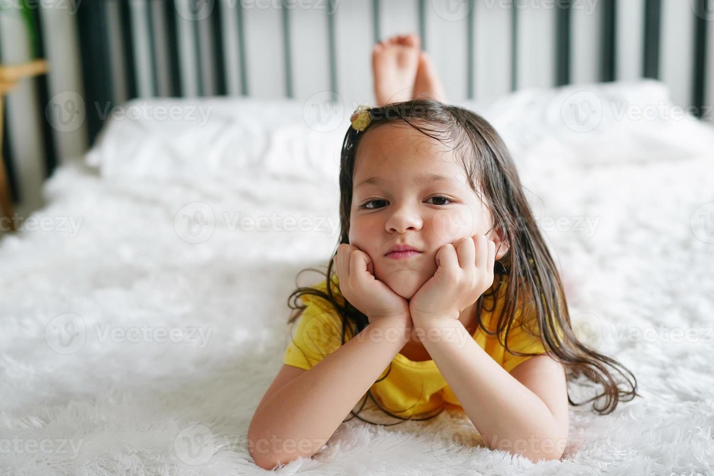 Little girl lying on bed and look at camera. 9814849 Stock Photo at