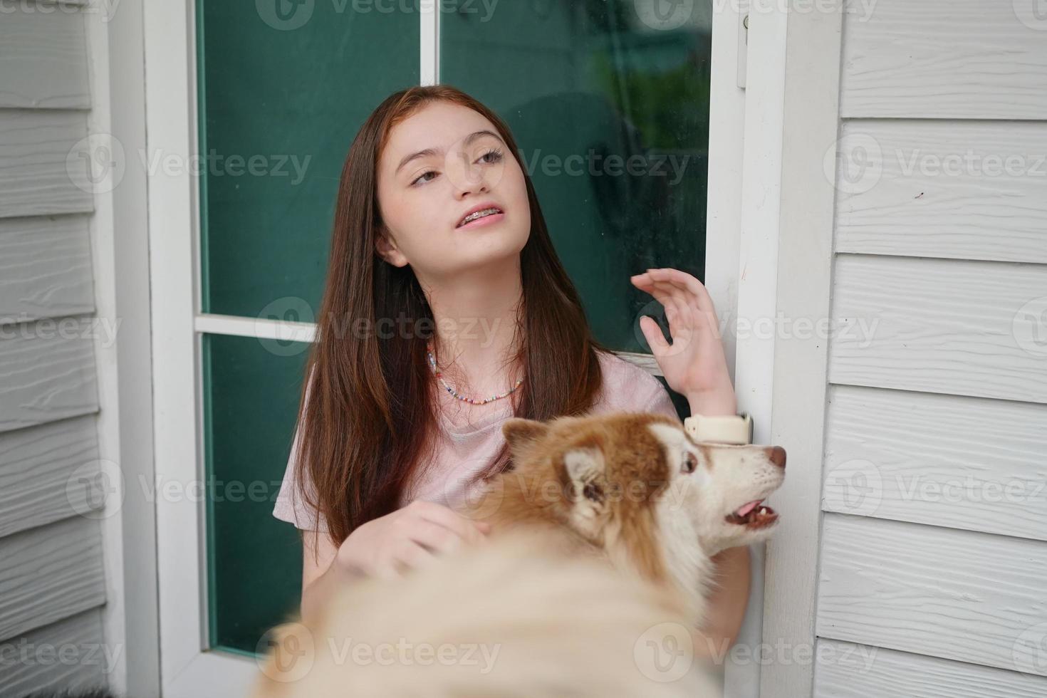 jovencita con ropa informal abrazando a un golden retriever mientras se sienta en el suelo foto