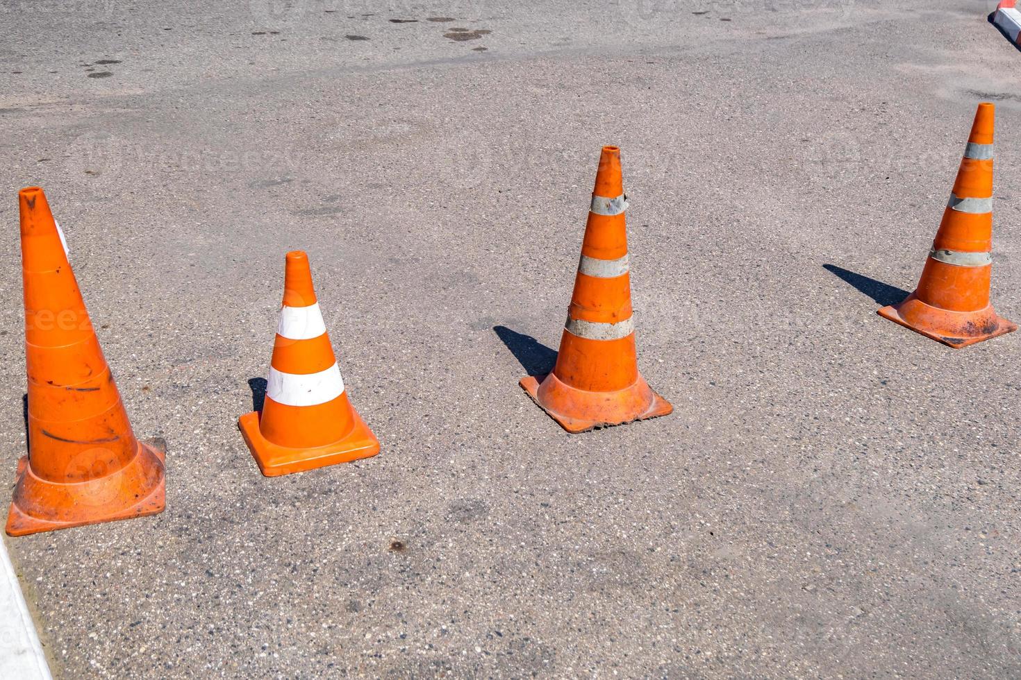 cono de peligro de tráfico naranja blanco en la reparación de carreteras de asfalto foto