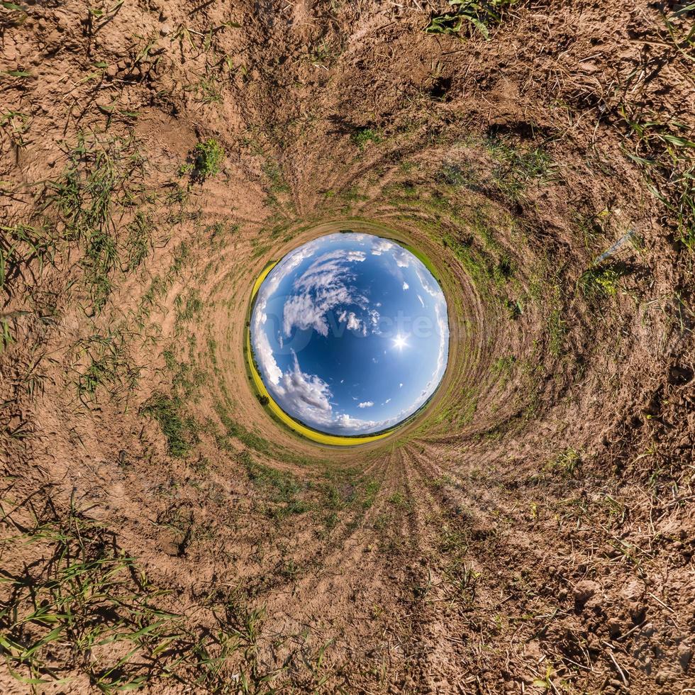 Inversion of little planet transformation of spherical panorama 360 degrees. Spherical abstract aerial view in field with awesome beautiful clouds. Curvature of space. photo