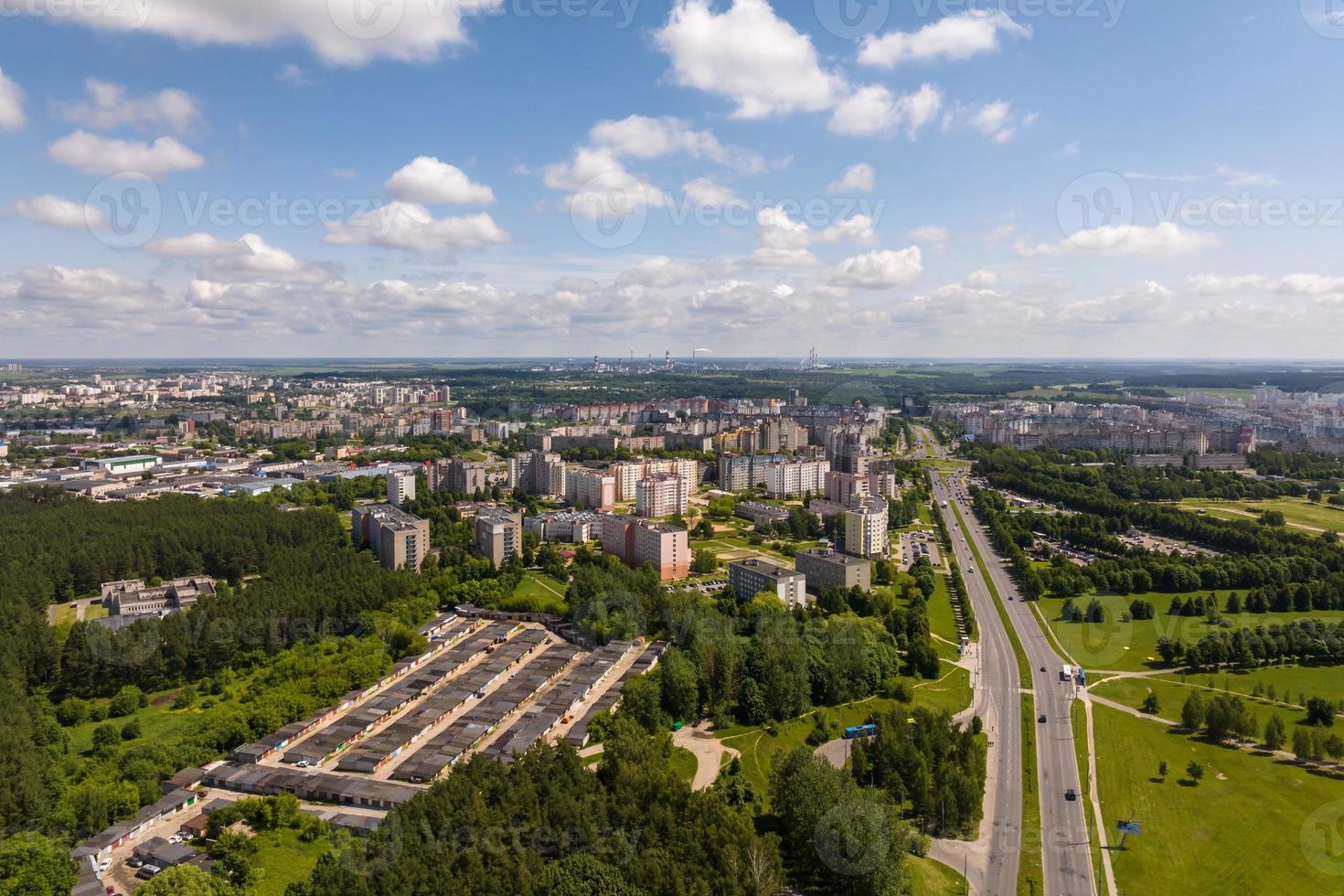 aerial panoramic view from great height on red roofs of old big city with skyscrapers and white fluffy clouds photo