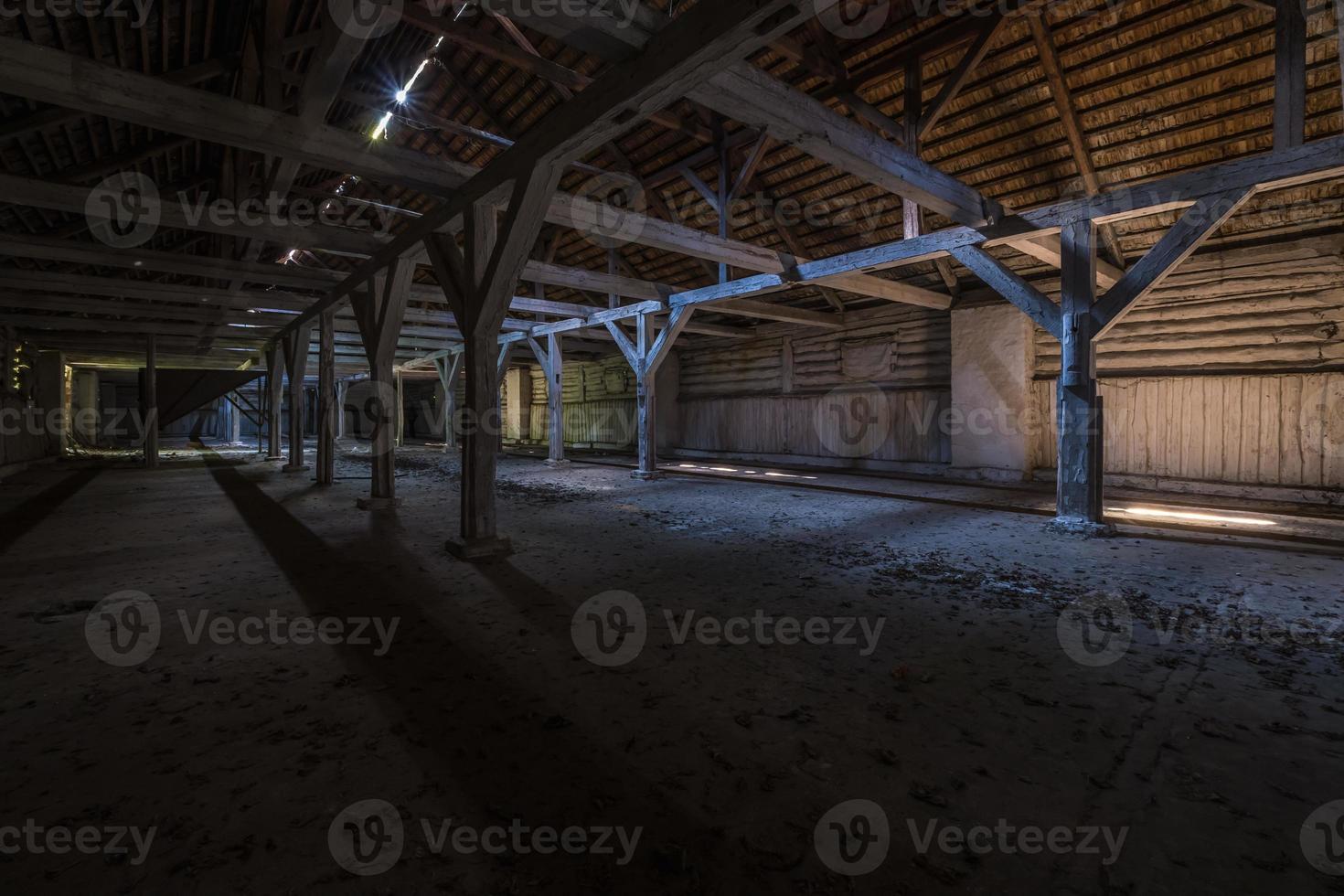 inside dark abandoned ruined wooden decaying hangar with rotting columns photo