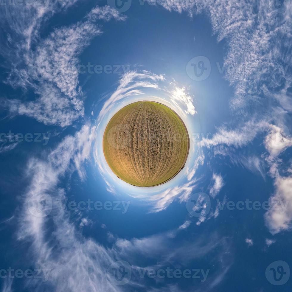 Little planet transformation of spherical panorama 360 degrees. Spherical abstract aerial view in field with awesome beautiful clouds. Curvature of space. photo