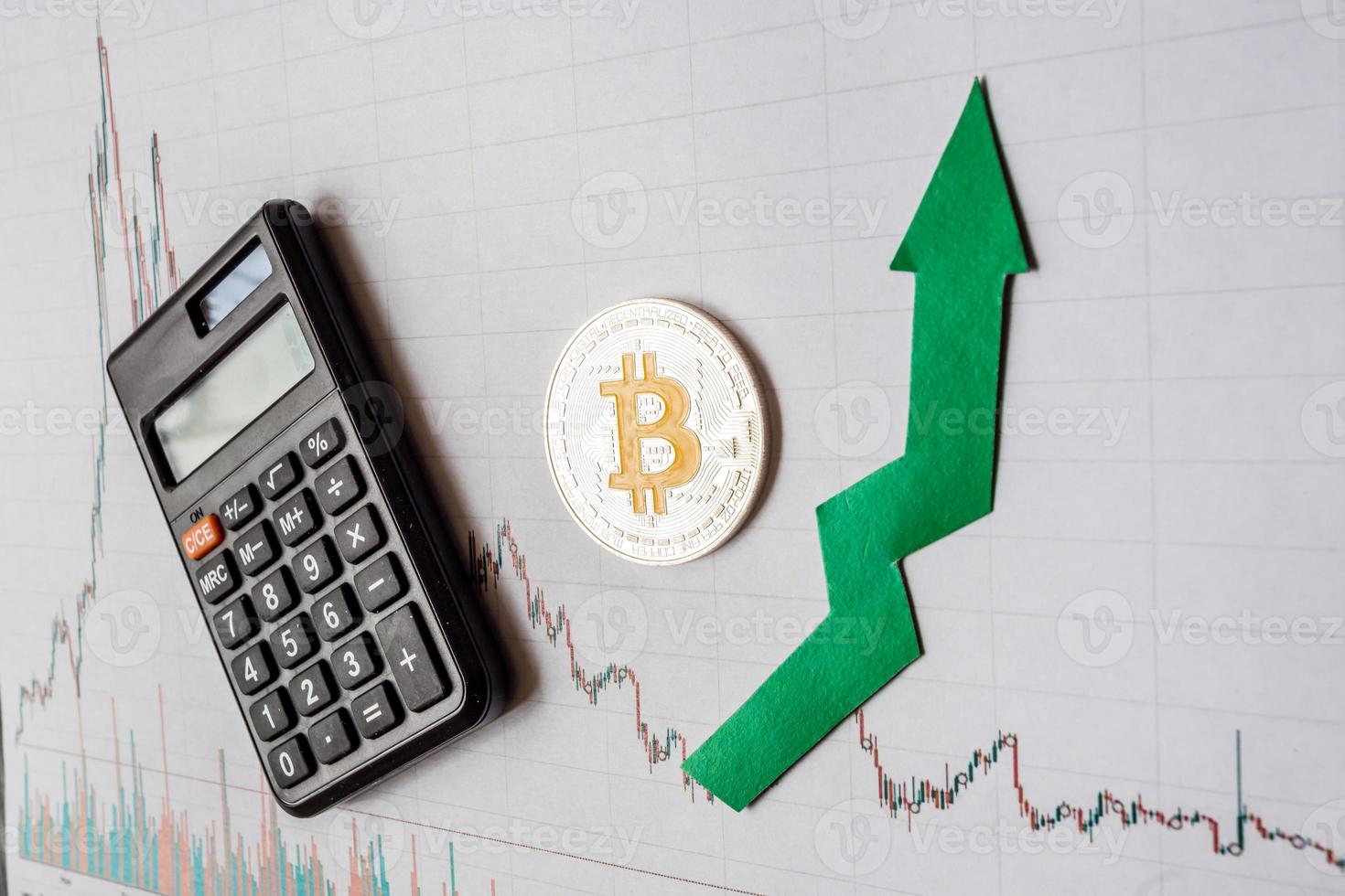 apreciación del dinero virtual bitcoin. la flecha verde y el bitcoin plateado en la calificación del índice del gráfico de divisas en papel suben el fondo del mercado de intercambio con la calculadora. concepto de apreciación de la criptomoneda. foto