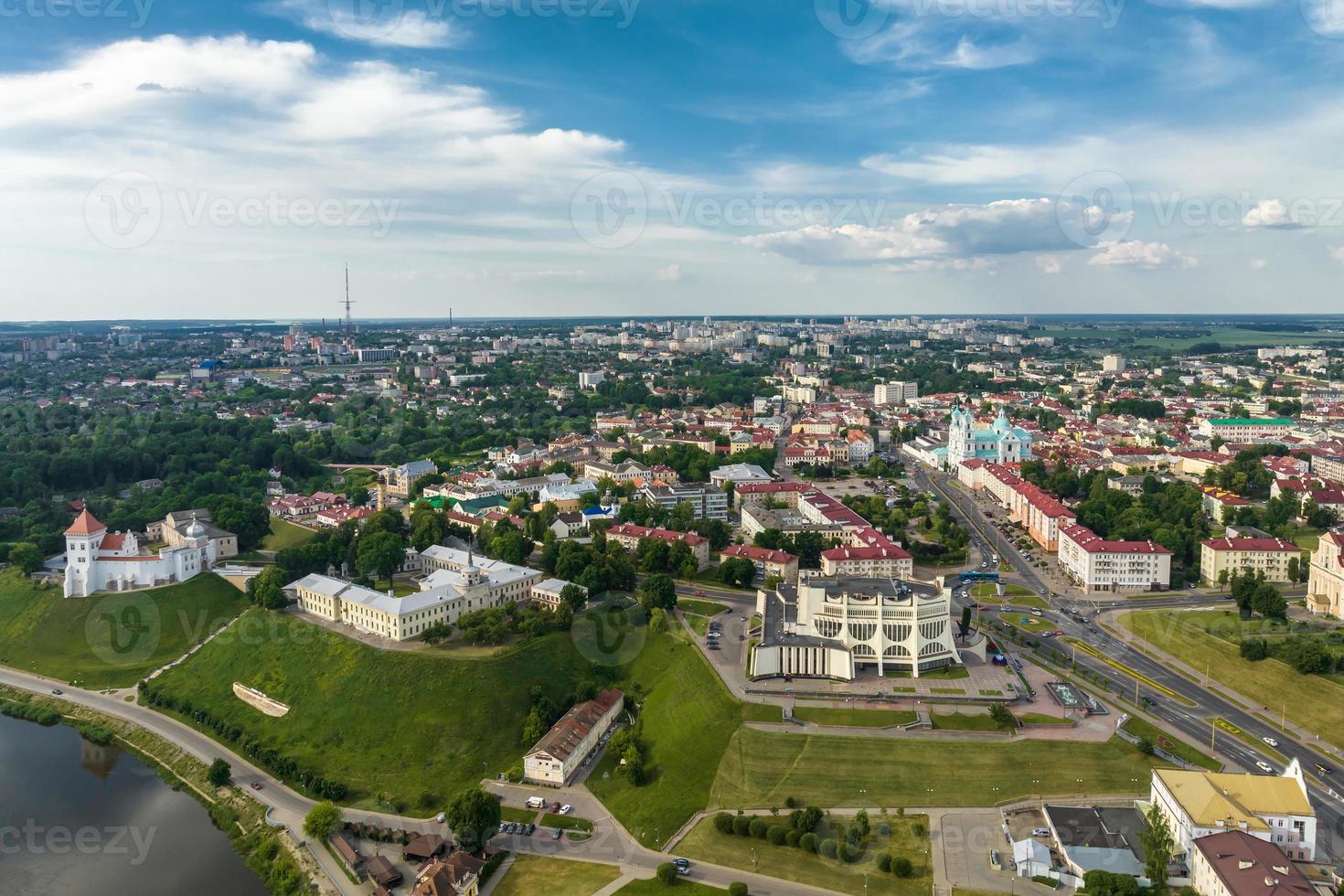 aerial panoramic view from great height on red roofs of old big city with skyscrapers and white fluffy clouds photo