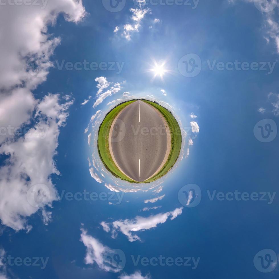 tiny planet in blue sky with sun and beautiful clouds. Transformation of spherical panorama 360 degrees. Spherical abstract aerial view. Curvature of space. photo