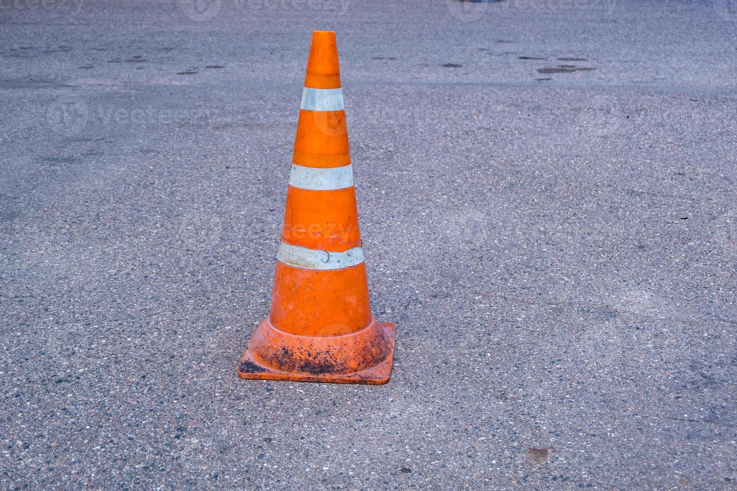 White orange traffic hazard cone on asphalt road repair photo