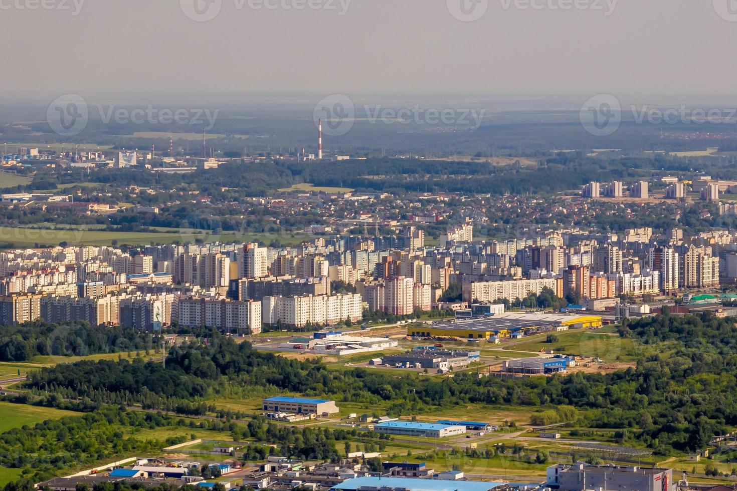 aerial panoramic view from great height on red roofs of old big city with skyscrapers and white fluffy clouds photo