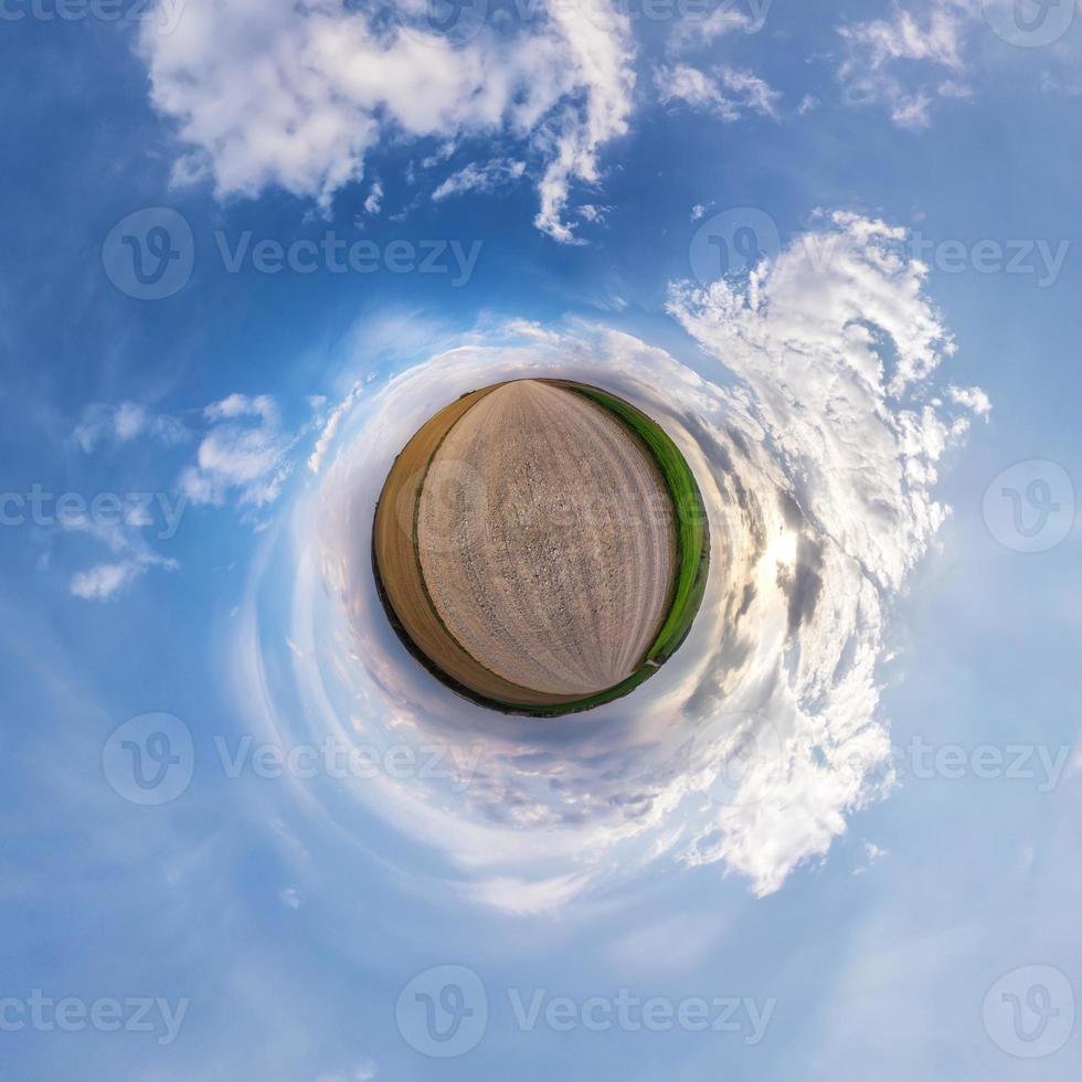 Little planet transformation of spherical panorama 360 degrees. Spherical abstract aerial view in field with awesome beautiful clouds. Curvature of space. photo