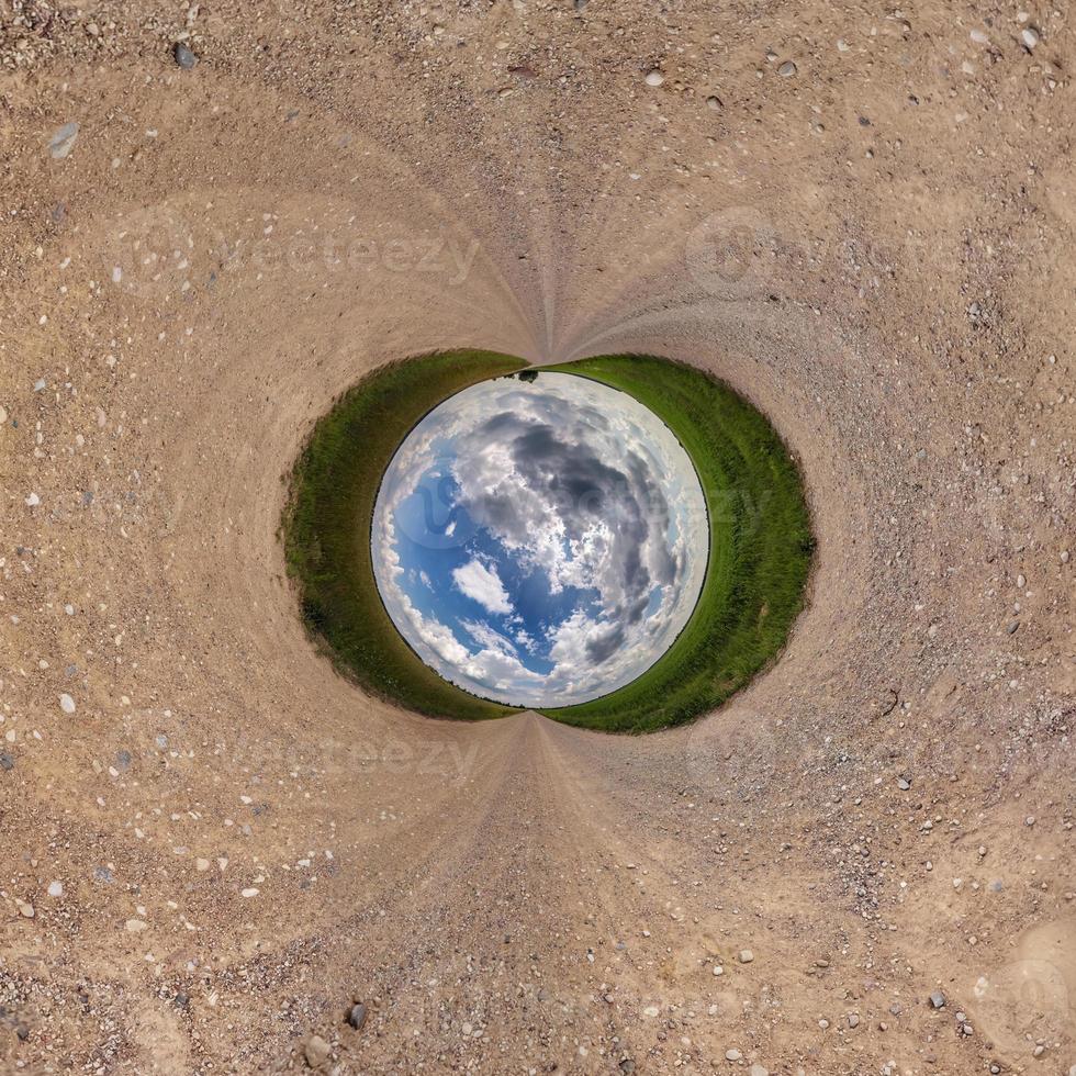 Inversion of blue little planet transformation of spherical panorama 360 degrees. Spherical abstract aerial view on road with awesome beautiful clouds. Curvature of space. photo