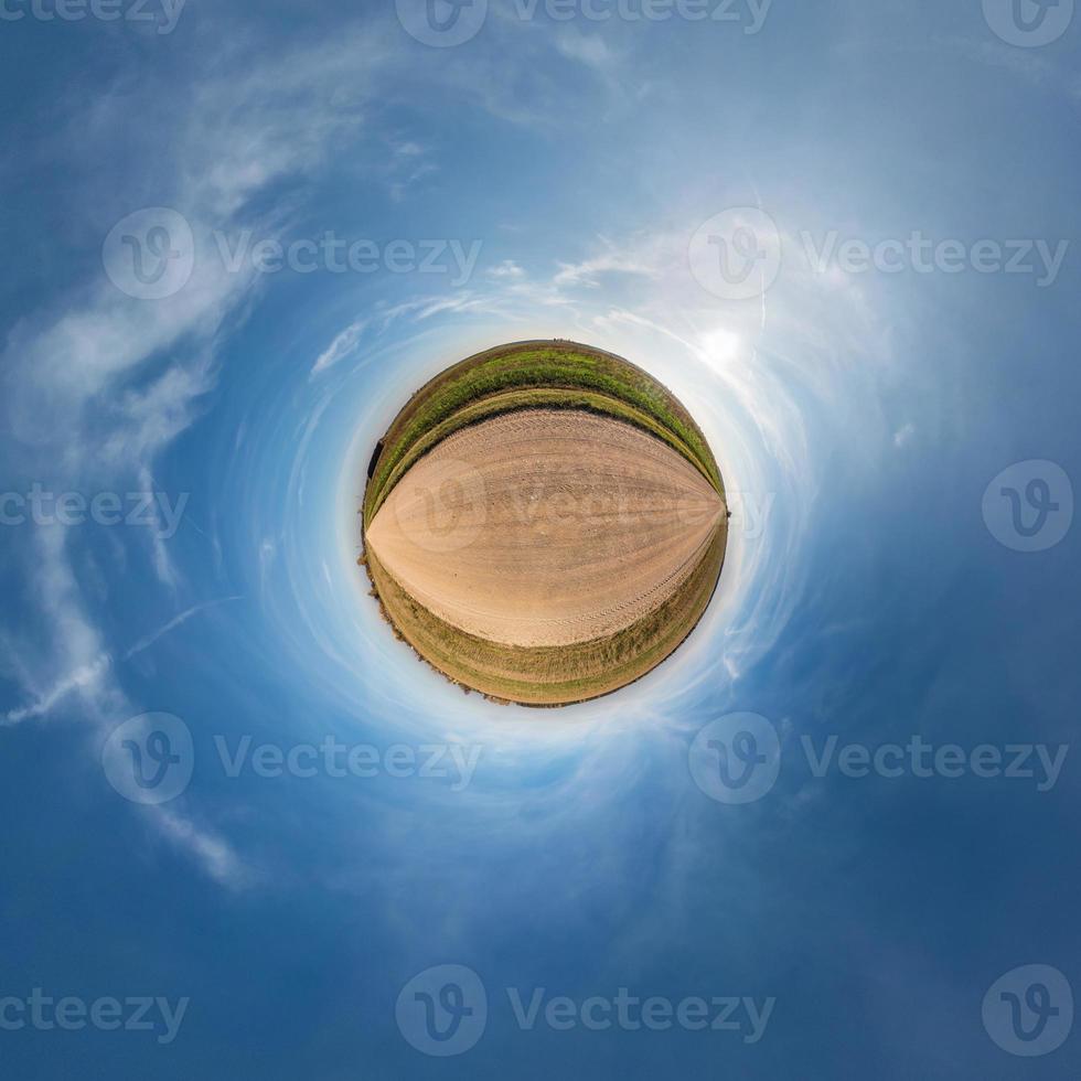 Little planet transformation of spherical panorama 360 degrees. Spherical abstract aerial view in field with awesome beautiful clouds. Curvature of space. photo