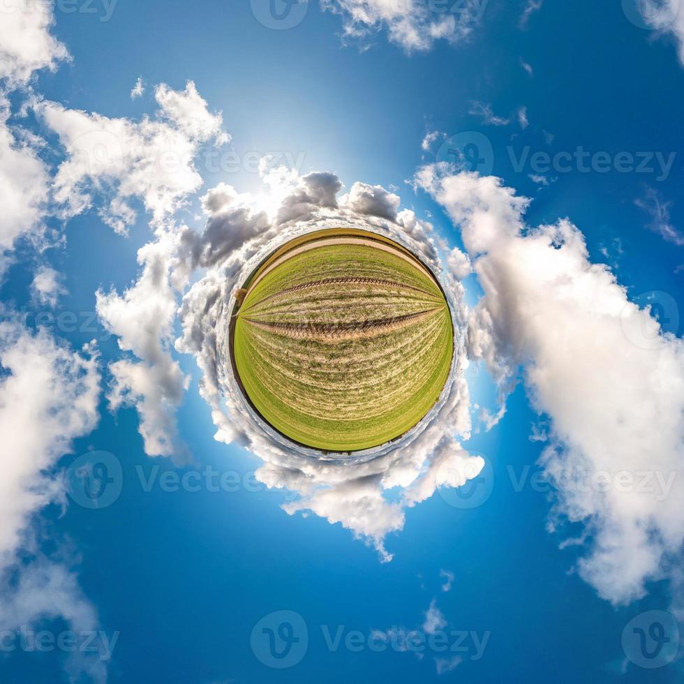 Little planet transformation of spherical panorama 360 degrees. Spherical abstract aerial view in field with awesome beautiful clouds. Curvature of space. photo