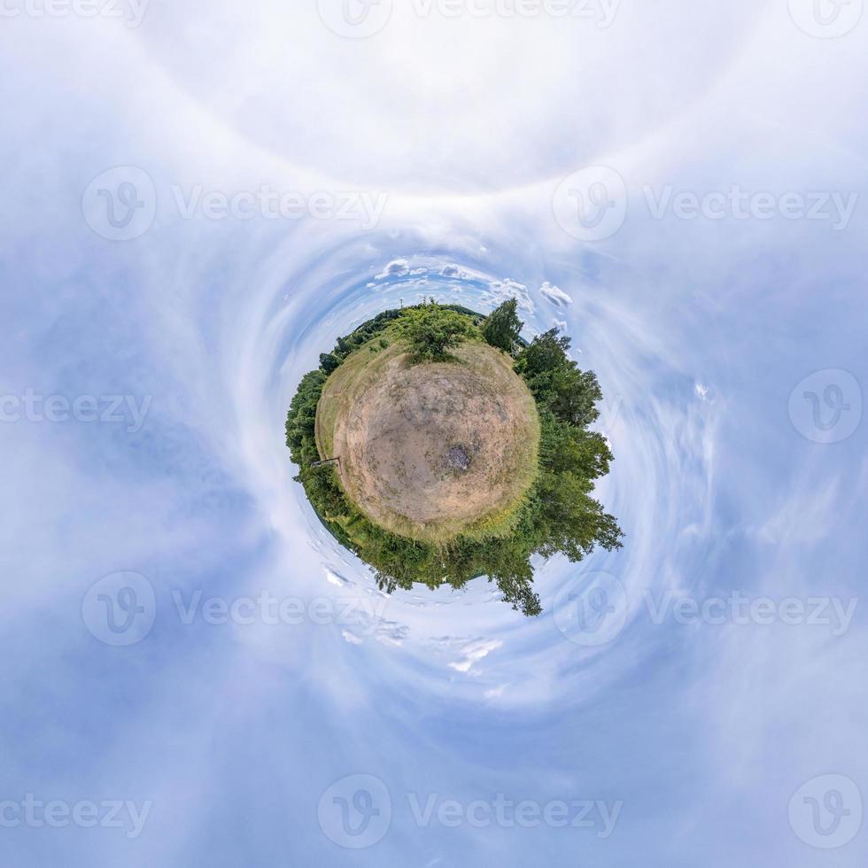 tiny planet in blue sky with sun and beautiful clouds. Transformation of spherical panorama 360 degrees. Spherical abstract aerial view. Curvature of space. photo