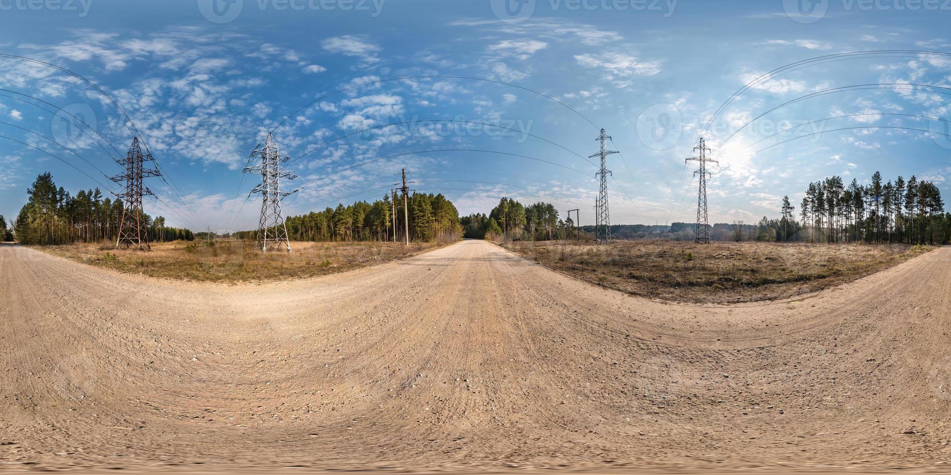 vista de ángulo de 360 grados de panorama hdri esférico completo sin fisuras cerca de torres de pilón eléctrico de alto voltaje en camino de grava en proyección equirectangular, contenido vr ar foto