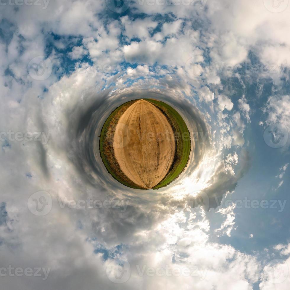 Little planet transformation of spherical panorama 360 degrees. Spherical abstract aerial view in field with awesome beautiful clouds. Curvature of space. photo