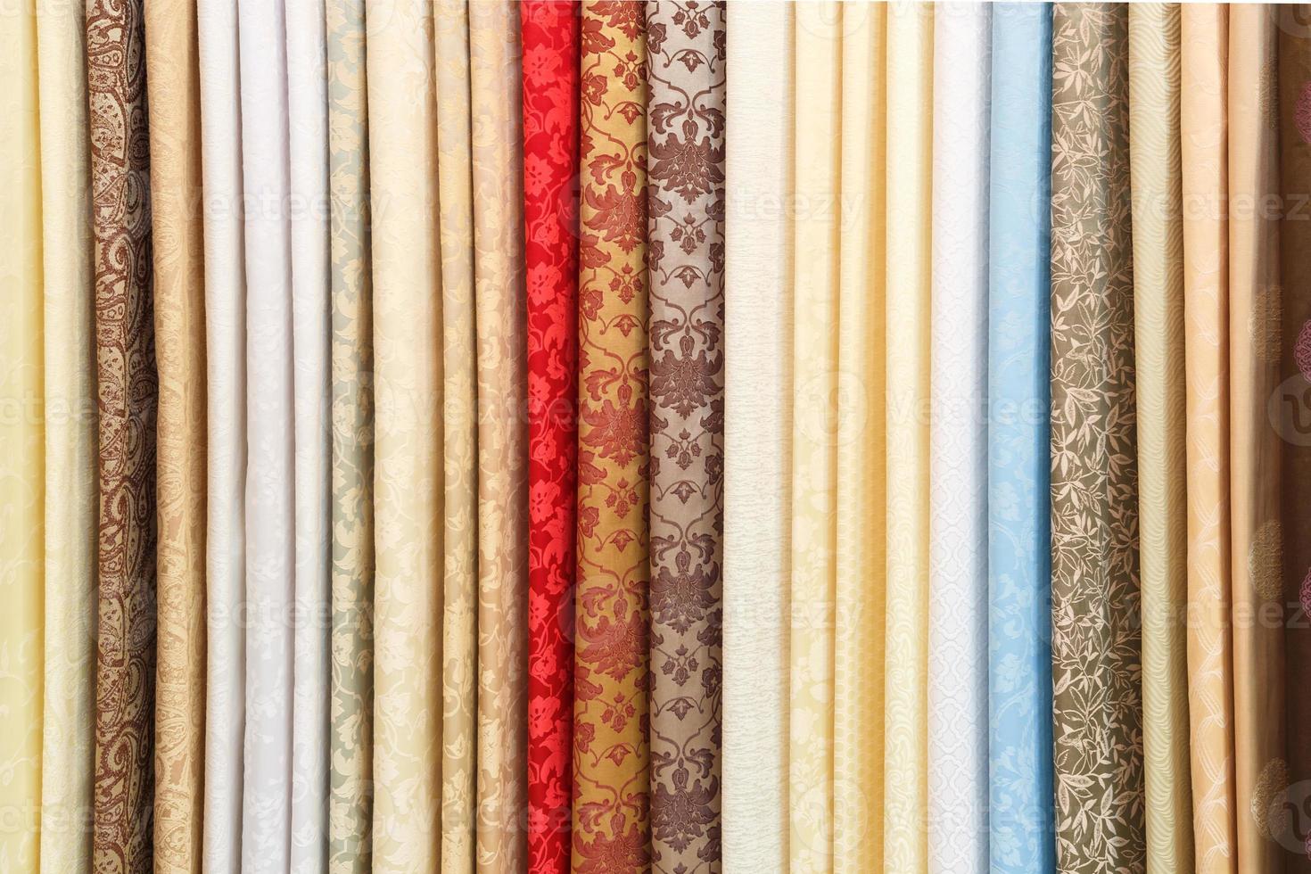 wide selection of different color textile silk fabrics clothes lay in row in drapery store photo