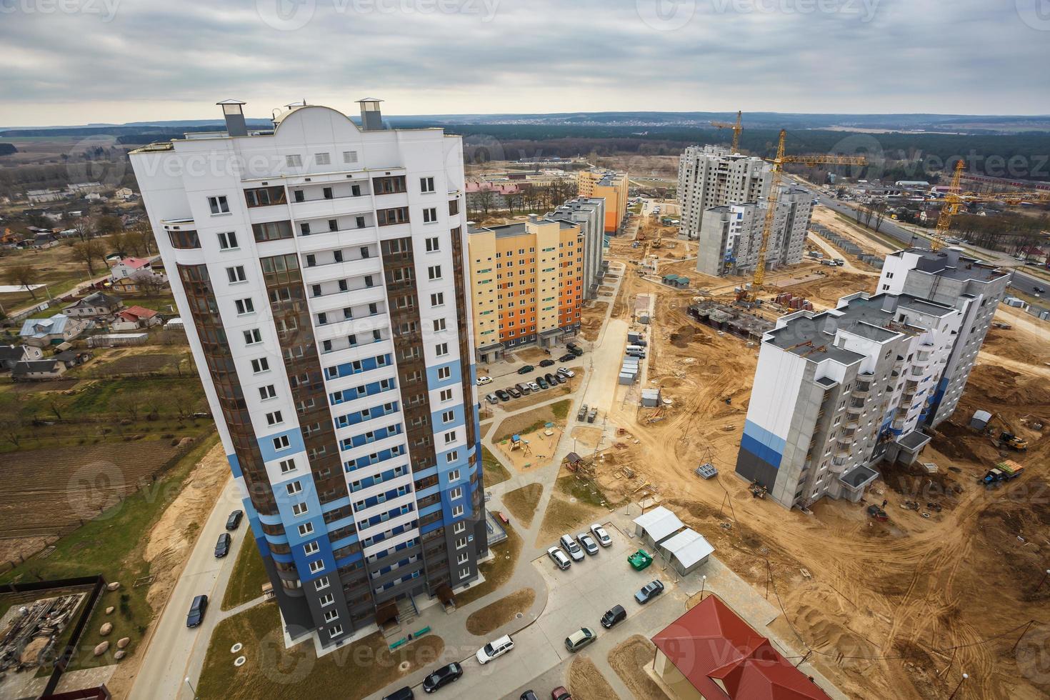Panoramic view on construction of  new quarter Tower unfinished multi-storey high building from a bird's eye view with forest on background photo