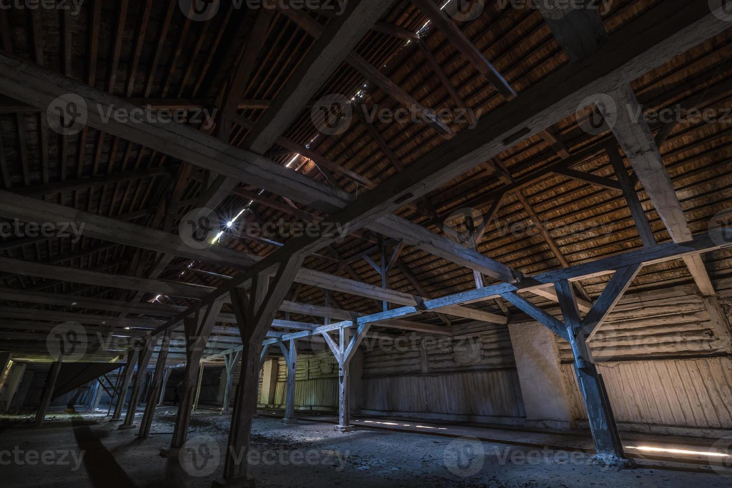 inside dark abandoned ruined wooden decaying hangar with rotting columns photo